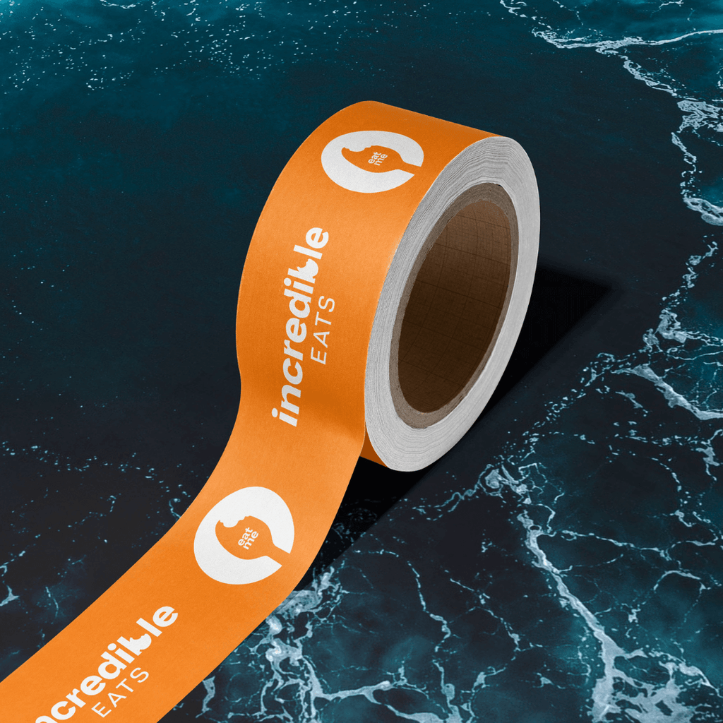 A photo of a tape roll with the logos for Incredible Eats on it. The tape is orange.
